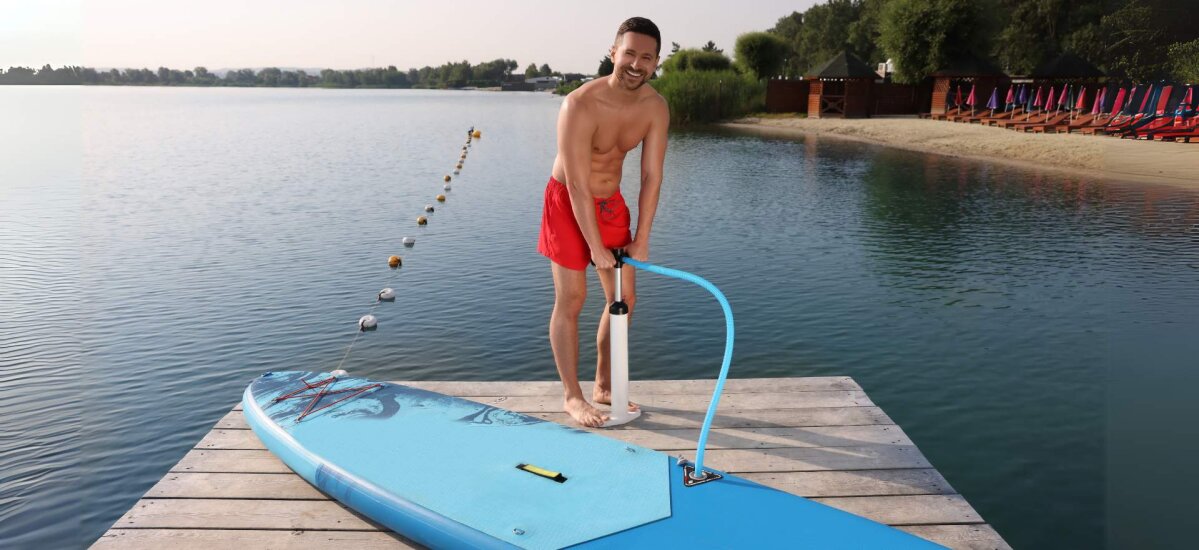 Čovjek stoji na sup daski i napuhava do tražene granice pritiska